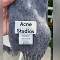 Acne Studios grey scarf worn by model over cream coat
